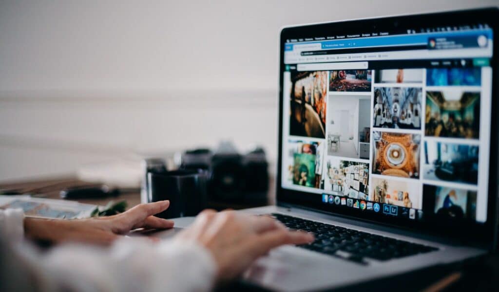 Person browsing a photo gallery on a laptop while researching website SEO optimization content